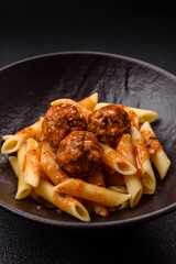 Penne pasta with meatballs in tomato sauce with salt and spices. Italian food penne pasta