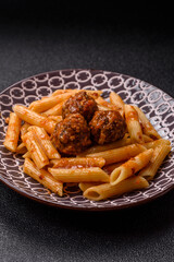 Penne pasta with meatballs in tomato sauce with salt and spices. Italian food penne pasta