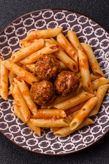 Penne pasta with meatballs in tomato sauce with salt and spices. Italian food penne pasta