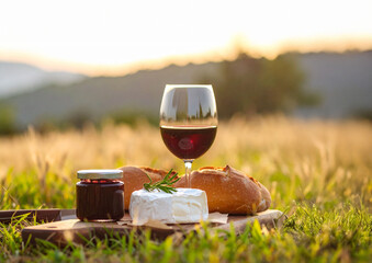 verre de vin rouge et plateau de fromages , à déguster à la campagne