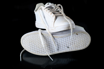 Worn Out White Sneakers with Visible Dirt on Black Background Close Up
