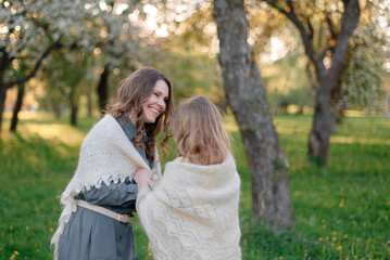 Mom and daughter play in the city park. They take care, cover each other with a handkerchief so as not to freeze. The concept of family, health, and care
