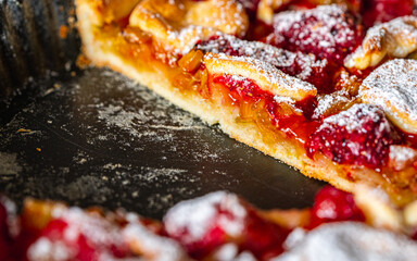 Rhubarb pie with strawberries on a baking sheet in a cut. Close-up.
