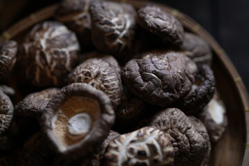 Close-up of dried shiitake mushrooms in bamboo basket. Traditional Asian ingredient used for soup, stir-fry, and herbal medicine. Organic texture and natural food background.