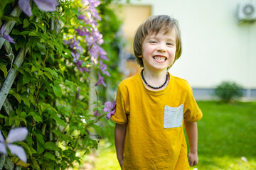 Adorable little boy having fun outdoors on sunny summer day. Kid running outdoors. Child exploring...