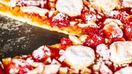 Rhubarb pie with strawberries on a baking sheet in a cut. Close-up.
