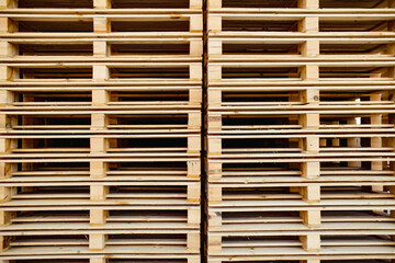 Organized stack of wooden pallets, creating a rhythmic pattern of lines and gaps, all suggesting readiness for heavy-duty transport, storage, or industrial use.