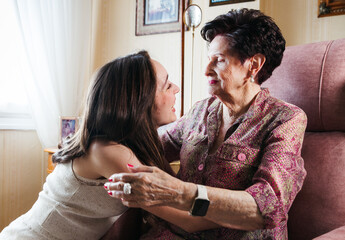 Young granddaughter caring for her elderly grandmother at home