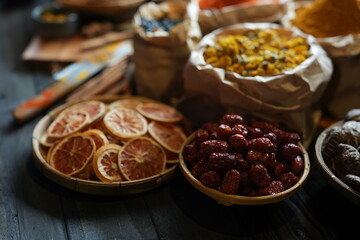 Close-up of dried orange slices in bamboo basket. Natural citrus fruit preserved for herbal tea, decoration, or culinary use. Rustic organic texture and food photography concept.