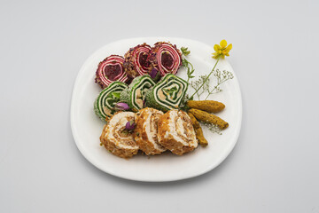Assorted sweet rolls rahat lokum with pistachios, cashews, decorated with rose petals on a ceramic...
