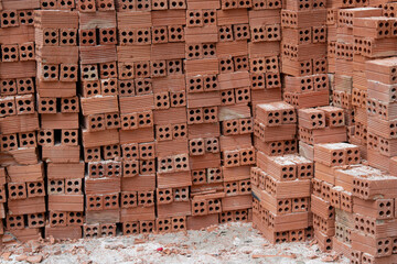 A large stack of red bricks, laid in neat rows on the ground.