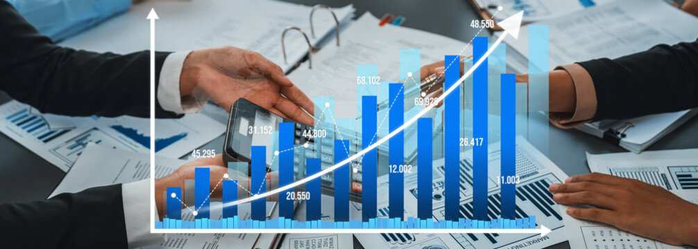 A dynamic business environment showcasing hands holding a smartphone over a financial growth chart. Ideal for financial analysis, strategy development, and team collaboration visuals. Amity - Powered by Adobe