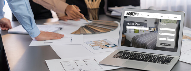 Group of interior architect designer discussing together on blueprint and laptop screen display...