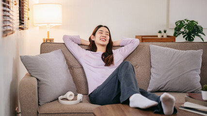 A woman is sitting on a couch with her arms crossed and a smile on her face