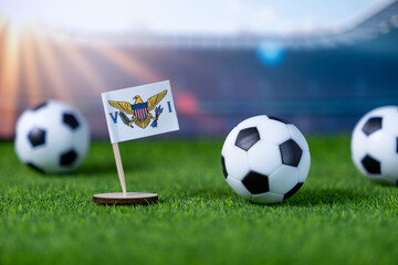 Miniature US Virgin Islands flag stands prominently amidst classic soccer balls on a vibrant green...
