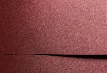 Fototapeta premium Chic paper closeup. Monochrome red and marsala surface with metallic gloss, geometric overlap,