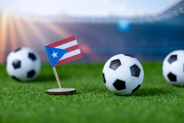 Vibrant Puerto Rico flag and miniature soccer balls resting on lush green stadium grass, embodying...