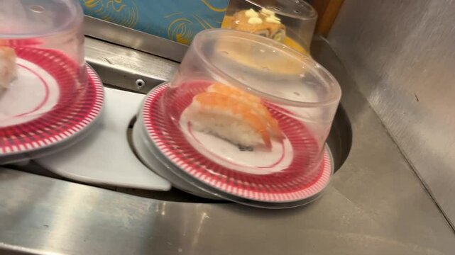 close up of sushi plate on conveyor belt in restaurant