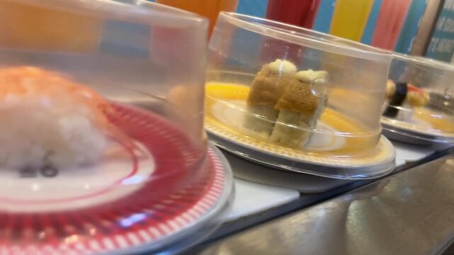 close up of sushi plate on conveyor belt in restaurant