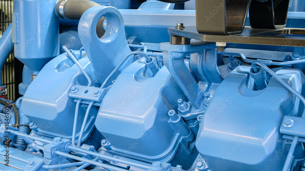 Poster blue engine with three cylinders. the engine is in a factory