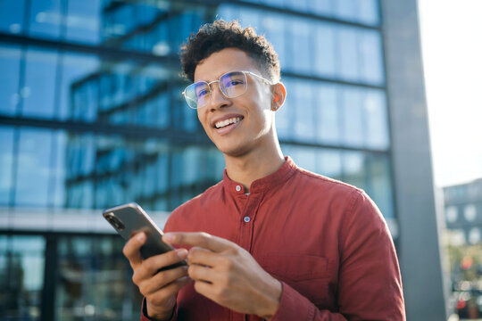 Happy Young Business Manager Using Mobile Banking App Outdoors in the City