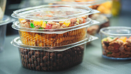 Container of food with nuts and fruit in it. The container is clear and has a lid.