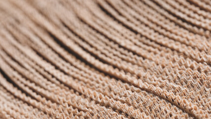 A long brown strip of thin sheets of kraft paper with line pattern. texture is rough and the lines are close together, creating a sense of depth and volume. scene is one of warmth