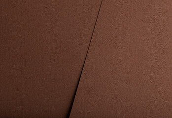 Luxury background with overlapping sheets of designer paper in chocolate brown tones. Pitted porous