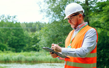 Eco control. Male forestry inspector studying the condition of trees in the forest. Ecologist's...