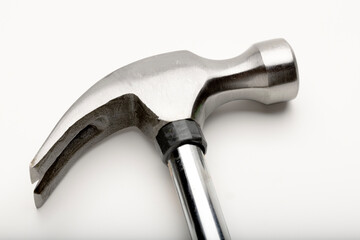 A close-up of a metallic hammer with a smooth handle and a curved claw. 