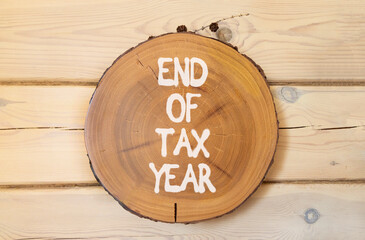 End of tax year symbol. Concept words phrase End of tax year on beautiful wooden circle. Beautiful...