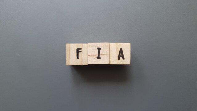 FIA acronym made of wooden letter cubes on dark background. Fonds d’Investissement Alternatif (Alternative Investment Fund)