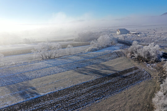 Aerial view of a small ranch in frosty misty winter weather