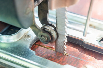 A carpenter cuts a board with an electric jigsaw