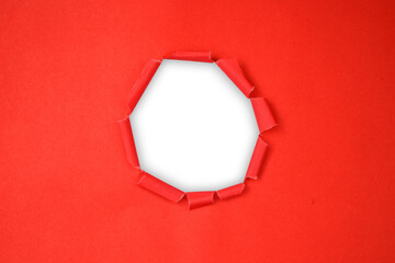Torn red paper with a circular hole, revealing a transparent background