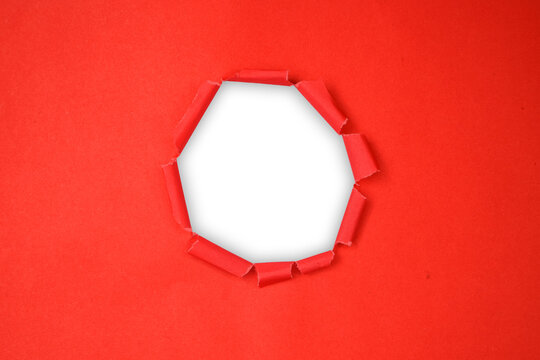 Torn red paper with a circular hole, revealing a transparent background