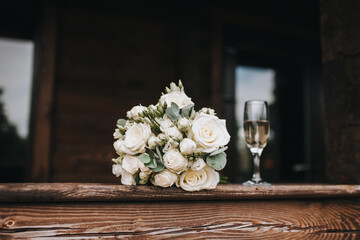 Wedding photo of a bouquet of beautiful flowers and a glass of champagne.