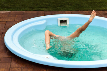 Girl athlete, child swimming in pool, jacuzzi, training, showing elements in synchronized swimming....