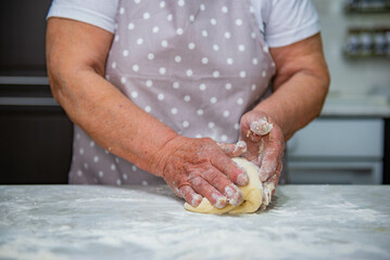 Granny baking buns in the kitchen. High quality photo
