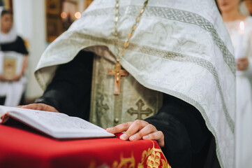 Close-up photo, portrait of Christian Orthodox priest with gilded cross in church during service...