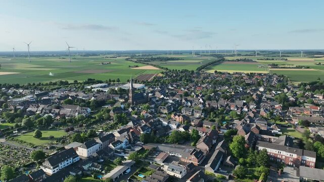 Luftbildaufnahme von Aldekerk bei Kerken mit Bahnhof an einem sonnigen Sommerabend. Weitwinkel-Drohnenflug &uuml;ber D&auml;cher, Felder und Gleisanlagen im warmen Licht der Abendsonne.