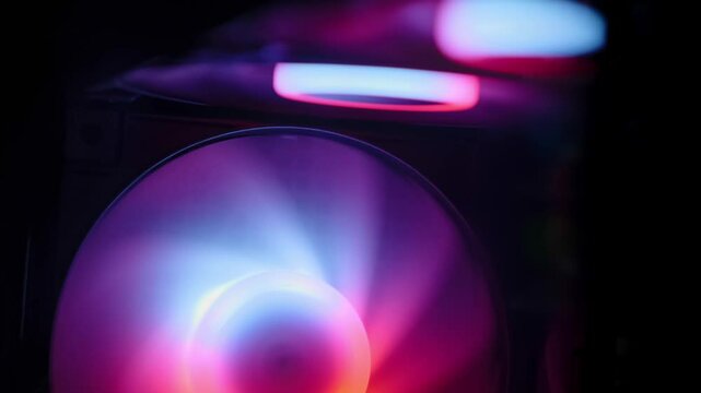 Vibrant RGB LED illuminated PC case fan spinning inside a sleek gaming desktop setup with dynamic lighting effects