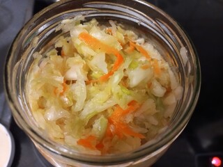 Homemade fermented sauerkraut with carrots in a glass jar for healthy eating. Sauerkraut in a jar. Fermented cabbage with carrots. Close-up, Top view. A typical dish of northern European countries