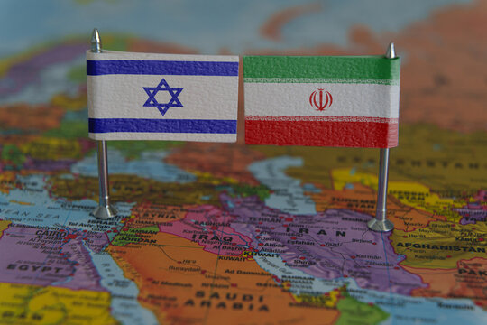 Flags of Israel and Iran placed on a map, symbolizing political tension or international relations.