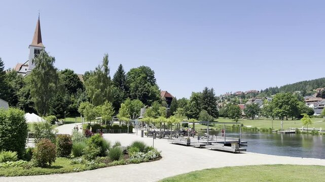 Schonach im Schwarzwald, Germany - 06 20 2024: View of the Kurpark and its lake in the city center of Schonach. Families with kids enjoy the hot summer day at the lake.