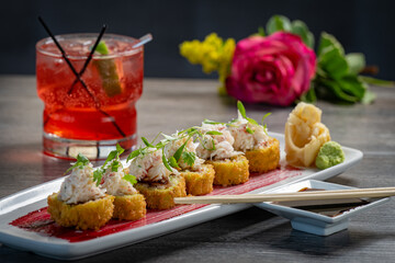 Crab Sushi Roll with tempura flakes and a red cocktail.