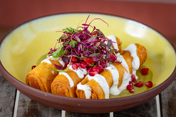 Potato flautas, drizzled with remoulade and topped with micro greens.