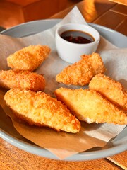 crab sticks in breadcrumbs with sauce on a plate. Food background
