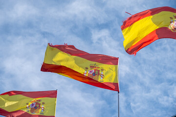 three flags of Spain fluttering in the wind spanish flags waving proudly against blue sky with...