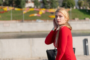 Fototapeta premium Woman in a red dress enjoying the city street on a sunny day